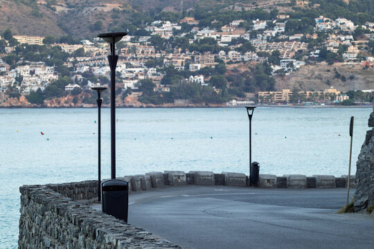 Coastal road curving along the sea with hillside town