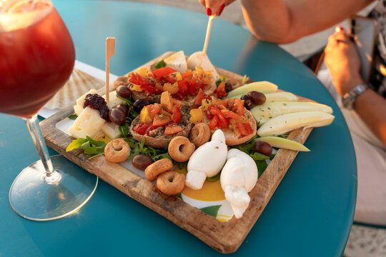 Traditional Apulian aperitivo with burrata bruschetta and cocktail