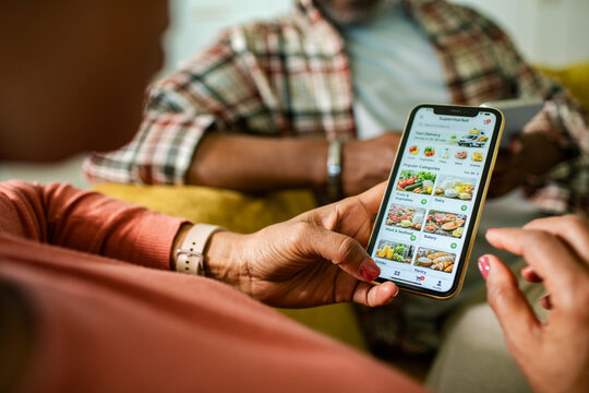 Person ordering groceries on smartphone at home