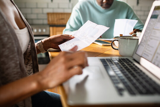 Couple reviewing household bills at kitchen table