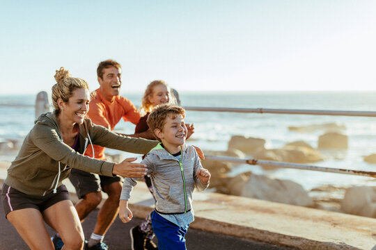 Family jogging together on seaside promenade