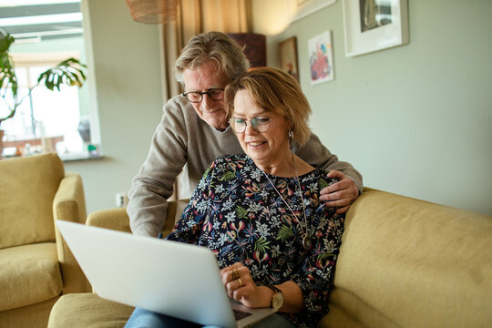 Senior couple using laptop together at home