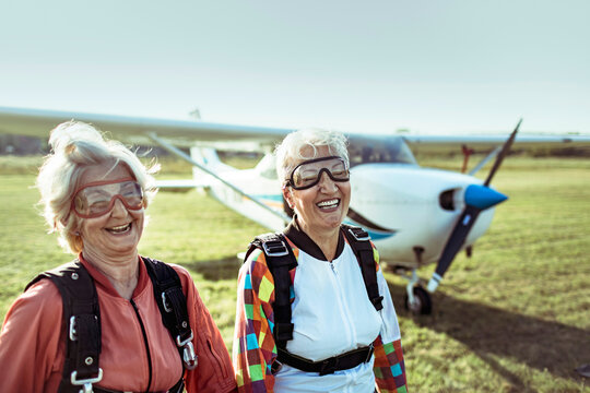 Two senior women skydivers laughing at airfield
