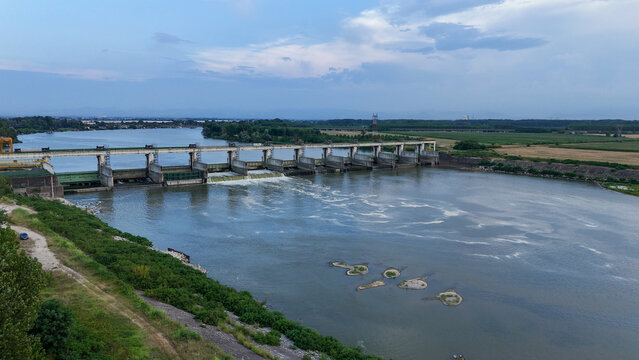 Isola Serafini Dam gates with low water exposing river islands on the Po River during a 2026 heatwave, highlighting critical drought and climate change impacts