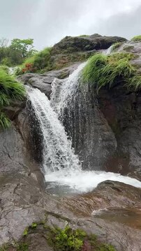 Twin waterfalls in mesmerizing slow motion amidst lush monsoon landscapes.