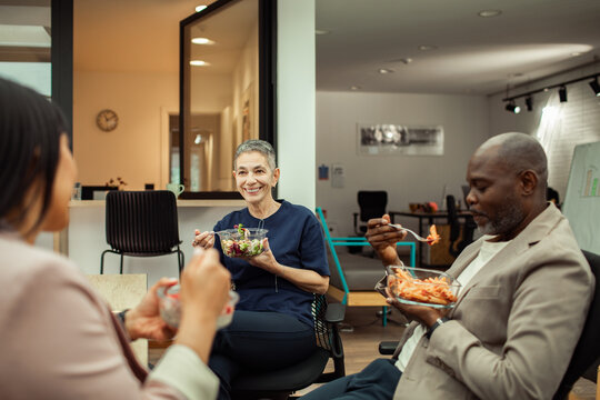 Coworkers sharing lunch break in modern office