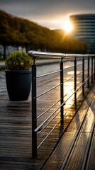 Obraz premium Wide angle view of a terrace at sunset with wooden floor and metal railing under golden light and background trees and buildings