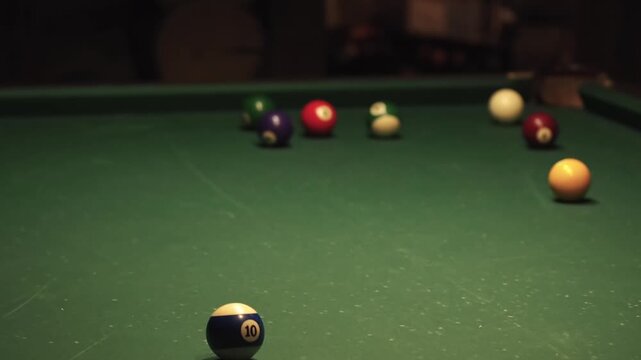 A game of pool. Dim lighting in the billiard room. A close-up of a failed shot with the cue ball