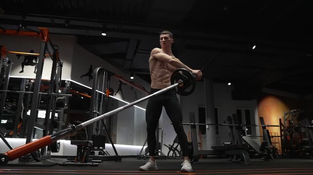 Shoulder exercise. Workout training. Athletic man performing landmine exercises with barbell. Strength and fitness. Muscular sportsman in sport gym do landmine exercise. Sport sportsman