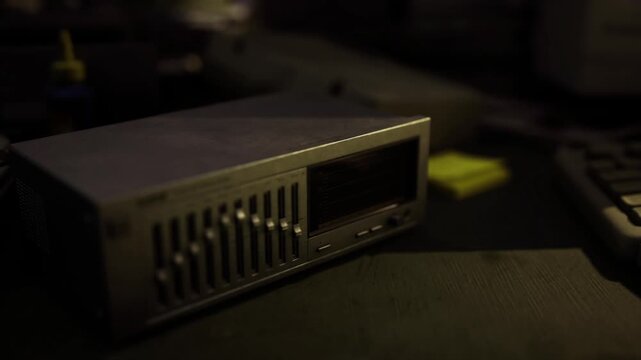 Low light network switch on workbench, dusty metal casing, dim LEDs glowing, shallow depth of field, foreground focus, industrial nostalgia and repair
