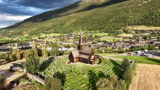 Aerial landscape of famous Norwegian landmark Lom Stave Church illuminated by setting sun