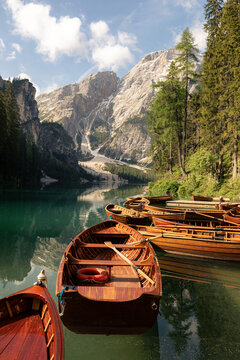 Traditional rowing wooden boats on calm water of Lago di Braies lake in mountain landscape of Dolomites Alps Italy. Outdoor recreation, eco tourism, summer vacation and alpine nature concept.