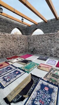 Open-air prayer area with colorful mats at historic Masjid Bani Anif in Medina.