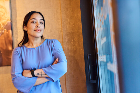 Portrait of a young  businesswoman woman posing in front of a wall in the office