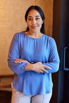 Portrait of a young  businesswoman woman posing in front of a wall in the office