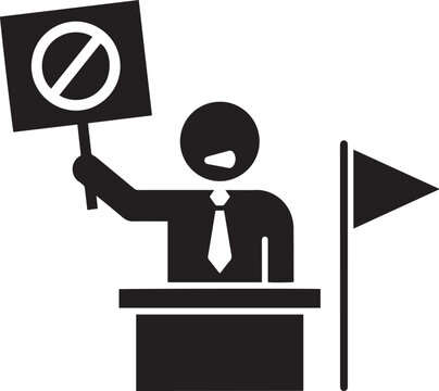 A protestor holding a sign with a prohibition symbol, standing at a podium with a flag beside him
