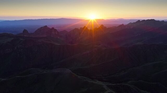 Aerial view of dramatic mountain peaks during a vibrant sunset in Xinjiang. Perfect for nature, travel, and adventure concepts.