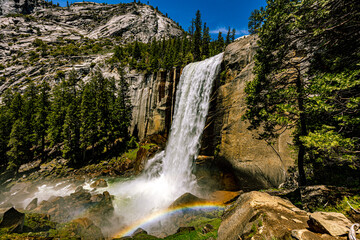 Vernal Fall cascades down a granite cliff into a misty pool, creating a vivid rainbow in Yosemite National Park, California.  © ZL Visuals