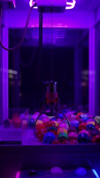 Claw machine arcade game with colorful spheres neon lights