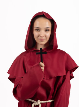 Mysterious woman wearing dark hood holding wooden cross symbol