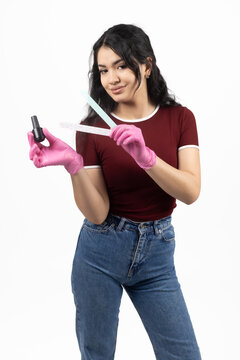 Young female student wearing headphones carrying books in studio
