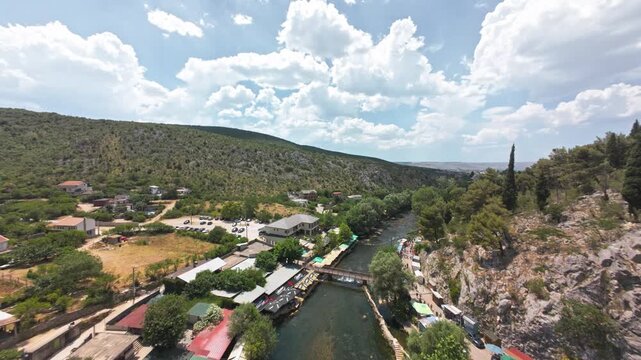 Aerial view of Blagaj Tekke dervish house and Buna river spring under steep rock cliff in Bosnia