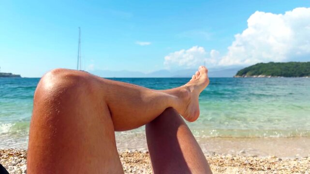 Relaxing Bare Legs Point Of View On Beach Opposite Clear Turquoise Sea Waters. Summer Resort Vacation 