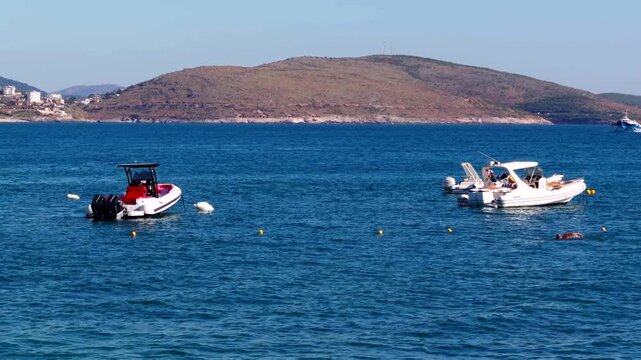 Motorboats Anchored On Calm Blue Sea Waters Against Scenic Coastal Hills. Summer Vacation. Marine Travel Resort