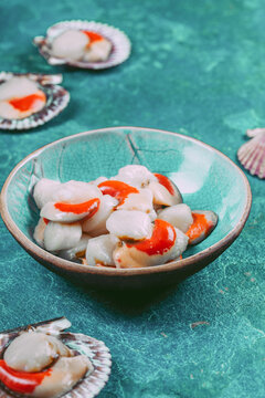 Raw fresh seafood shellfish scallops on blue background