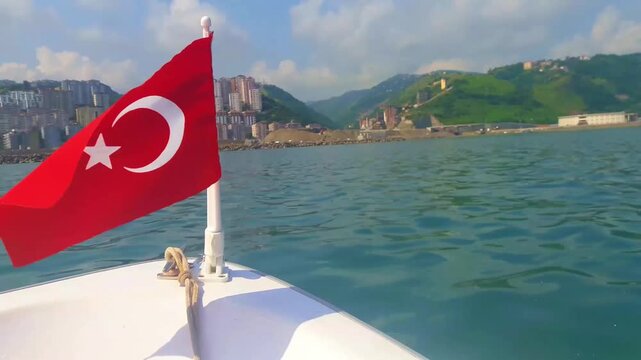 a small Turkish flag waving in front of a boat moving on the sea