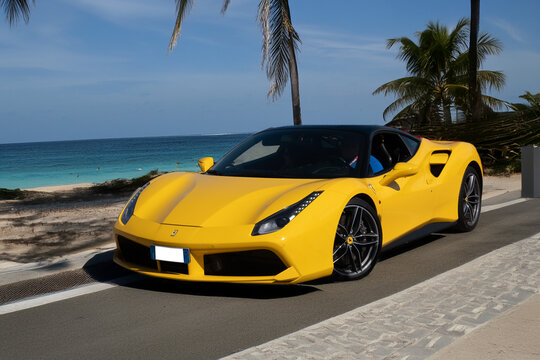 Luxury sports car on a coastal road with a tropical sea and palm trees in the background, ideal for travel, freedom, an exclusive lifestyle, and mobility. Editorial content.