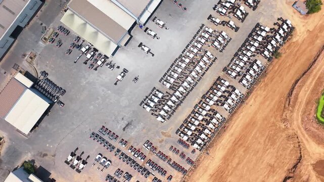 New compact excavators stored in ordered rows across a machinery manufacturing yard