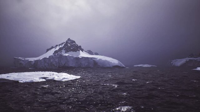 ice floe foreground with distant mountain backdrop and shimmering midsea reflections, cinematic composition emphasizing texture, scale and dramatic polar