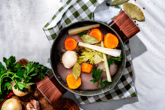 Raw chicken fillet soup preparation. Healthy culinary concept with fresh vegetables, onions, and herbs.