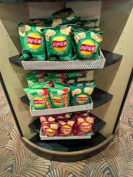ORLANDO, USA, 18TH MAY 2026: Assorted Asian Snacks and Potato Chips Displayed on Tiered Store Shelf