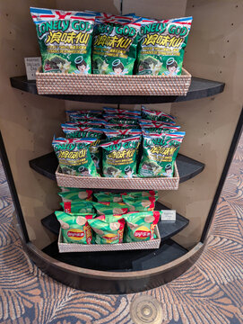 ORLANDO, USA, 18TH MAY 2026: Assorted Asian Snacks and Potato Chips Displayed on Tiered Store Shelf