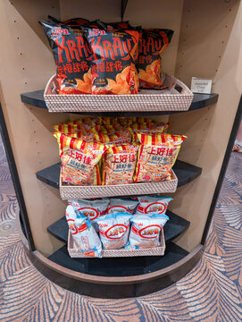 ORLANDO, USA, 18TH MAY 2026: Assorted Asian Snacks and Potato Chips Displayed on Tiered Store Shelf