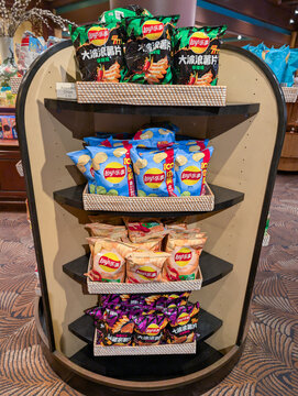 ORLANDO, USA, 18TH MAY 2026: Assorted Asian Snacks and Potato Chips Displayed on Tiered Store Shelf