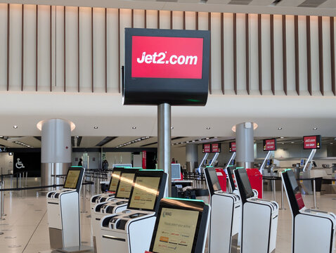 MANCHESTER, UK - JUNE 21 2026: Jet2.com check-in screen and self-service baggage drop kiosks in an airport terminal departure hall.