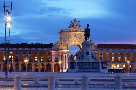 Augusta Arch illuminated at night, Comercio square , Lisbon. Baroque triumphal gateway, statues, columns, empty square, blue hour.
