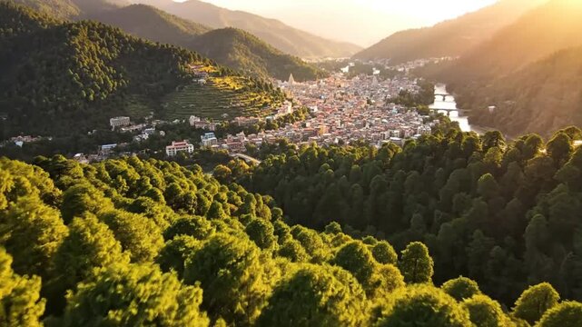 Scenic aerial view of a vibrant city nestled in the valley surrounded by lush green hills under a golden sunset