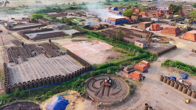 Traditional brick kiln surrounded by stacked bricks and drying rows