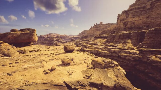 foreground boulder sitting on rugged plateau under wide sky, distant layered cliffs frame scene, composition suggests scout or photographer planning camp