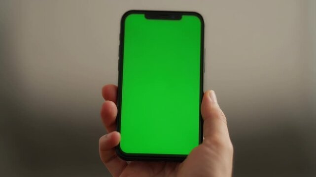 Hand Holding Smartphone with Green Screen for Mobile App Mockup