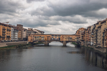 Fototapeta premium Famous historic Ponte Vecchio bridge and old buildings along the Arno river in Florence Italy