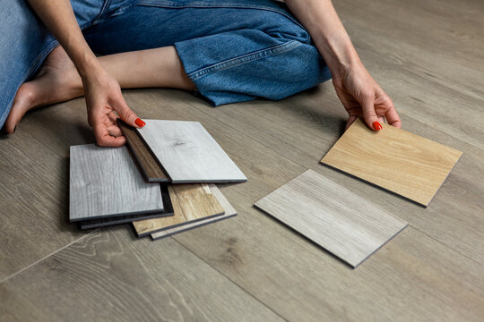 Woman choosing wood flooring samples for home renovation and interior design