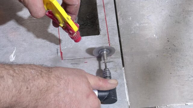 A rotating cutting disc cuts a hole in a ceramic tile