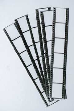 Overlapping Cut Out 35mm Film Strips on White Paper Background