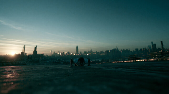 Person Prostrate on Rooftop Overlooking Manhattan Skyline