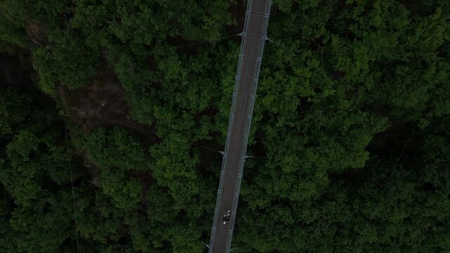Hikers crossing Geierlay suspension bridge seen from above